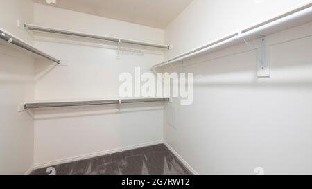 Pano Walk in closet of house with empty built in shelves and two levels ...