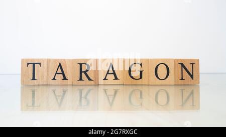 The word Taragon was created from wooden letter cubes. Gastronomy and spices. close up. Stock Photo