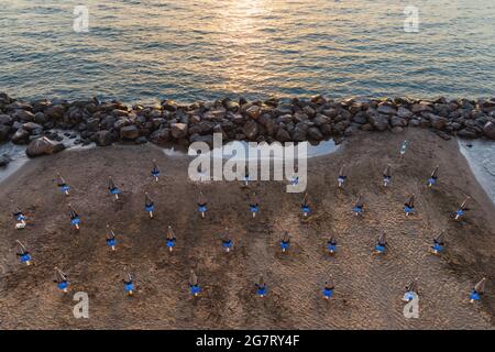 View from above to small beach full of blue and white umbrellas next to the sea Stock Photo
