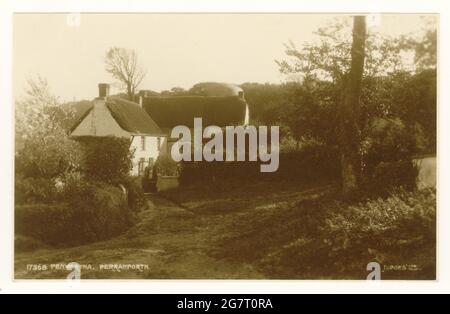 Original early 1900's postcard of idyllic view of thatched, cob built cottages, vernacular architecture, at Penwartha, an inland hamlet near Perranporth, Cornwall, U.K. Stock Photo