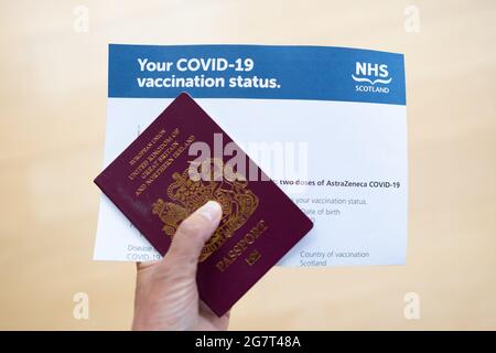 COVID-19 double vaccination certificate letter proving vaccination status issued by NHS Scotland with passport - Scotland, UK Stock Photo