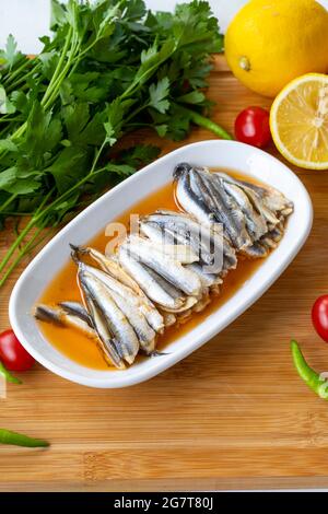 Marinated anchovies on wooden background. Seafood dishes Stock Photo