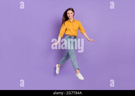 Full length body size photo jumping girl smile walking in casual outfit isolated violet color background Stock Photo