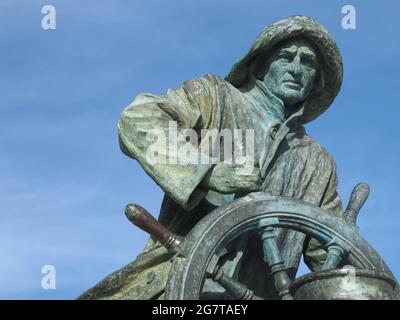 Bronze statue of a sailor with a wheel Stock Photo