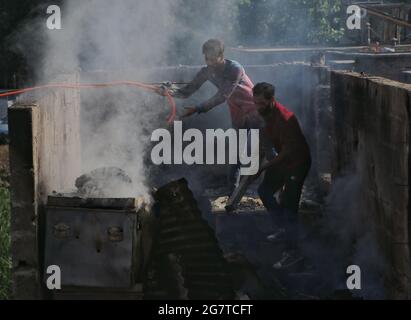 Srinagar, India. 16th July, 2021. Kashmiri boys cleaning the remaining derbis of a house which was damaged during a Gunfight in danmar area of Srinagar on 16-07-2021. (Photo by Muhammad Manan/Pacific Press/Sipa USA) Credit: Sipa US/Alamy Live News
