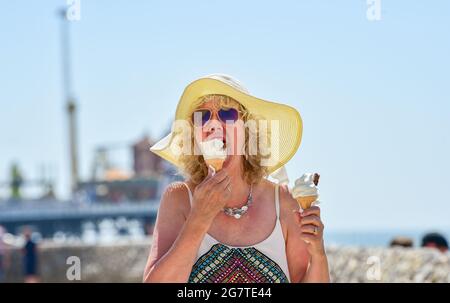 Brighton UK 16th July 2021 - Time for an ice cream or two on a beautiful hot sunny day in Brighton as the warm weather is forecast to continue over the next few days in Britain with temperatures expected to reach the high 20s over the weekend : Credit Simon Dack / Alamy Live News Stock Photo