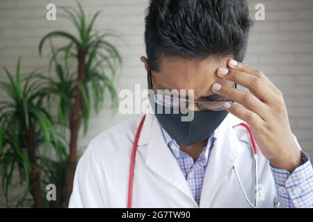 Depressed sad doctor covering face with hands  Stock Photo