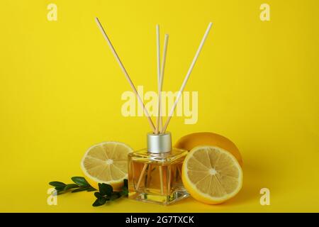 Diffuser, lemons and leaves on yellow background Stock Photo
