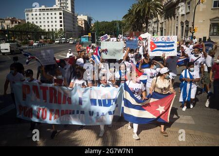 Malaga, Spain. 16th July, 2021. Protesters march with placards and Cuban flags as they take part in a demonstration in support of Cuban population. A group of Cuban residents in Malaga have marched along main streets in downtown under the slogan: 'Homeland and life' to demonstrate against government of Cuban president Miguel Diaz Canel, after social breakdown in Cuba demanding the end of the communist dictatorship. (Photo by Jesus Merida/SOPA Images/Sipa USA) Credit: Sipa USA/Alamy Live News Stock Photo