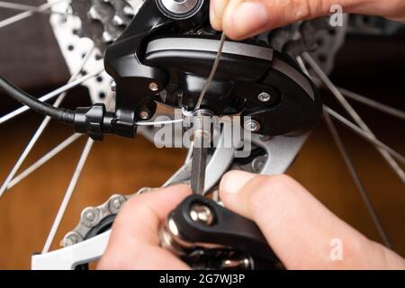 adjustment of gear shifting on a bicycle with a hexagon. Stock Photo