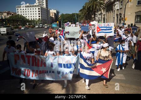 Malaga, Spain. 16th July, 2021. Protesters march with placards and Cuban flags as they take part in a demonstration in support of Cuban population. A group of Cuban residents in Malaga have marched along main streets in downtown under the slogan: 'Homeland and life' to demonstrate against government of Cuban president Miguel Diaz Canel, after social breakdown in Cuba demanding the end of the communist dictatorship. Credit: SOPA Images Limited/Alamy Live News Stock Photo