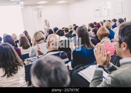 Woman giving interactive motivational speech at entrepreneurship workshop. Stock Photo