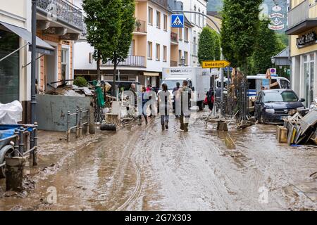 Bad Neuenahr, Germany. 16th July, 2021. People walk along a street that is still completely muddy. Massive rainfall has caused flooding in Bad Neuenahr in Rhineland-Palatinate as well as in the whole district of Ahrweiler. Credit: Philipp von Ditfurth/dpa/Alamy Live News Stock Photo