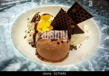 Chocolate and Vanilla ice cream in large bowl with chocolate sauce and wafers Stock Photo
