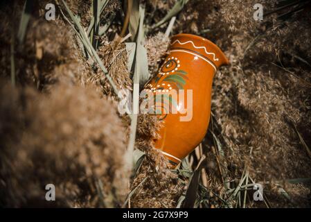 brown clay jug in the sun on reed background, a traditional concept Stock Photo
