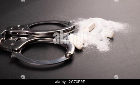 arrest of a drug dealer, handcuffs and cocaine white powder. Stock Photo