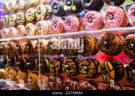 Colorful sweet background. Delicious glazed donuts on a shop window Stock Photo
