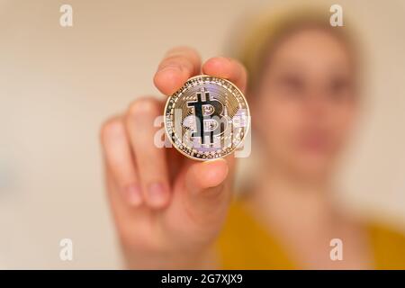 Close up view of woman holding Bitcoin cryptocurrency coin in her hand Stock Photo
