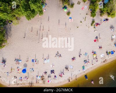 Aerial view from a drone of people who are resting on the sandy shore of the beach by the river outdoor Stock Photo