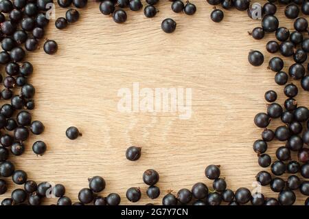 Fresh organic berries, black currant on wooden table. Frame, copy space for inscription Stock Photo