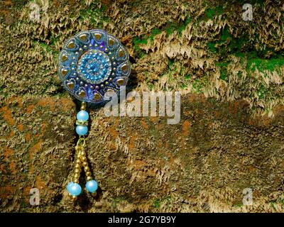 Female artificial ornament presented on green wall backdrop, woman lifestyle product natural presentation Stock Photo