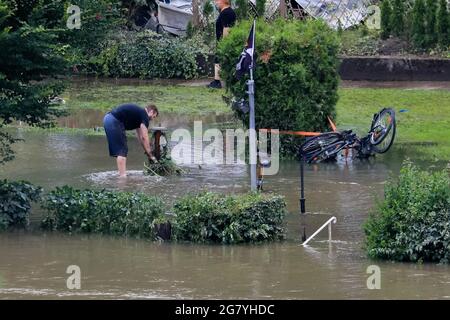 Hattingen, NRW, Germany. 16th July, 2021. Campers at 'An der Kost' campside have moved their vans to higher ground and battle the substantial water damage caused. The River Ruhr has flooded its embankment, fields and many gardens, basements and properties near the town of Hattingen in the Ruhr district in North-Rhine Westphalia. NRW has been hit by terrible floods, following heavy rain over the last few days. More than 80 people have died so far in the floods in Germany. Credit: Imageplotter/Alamy Live News Stock Photo