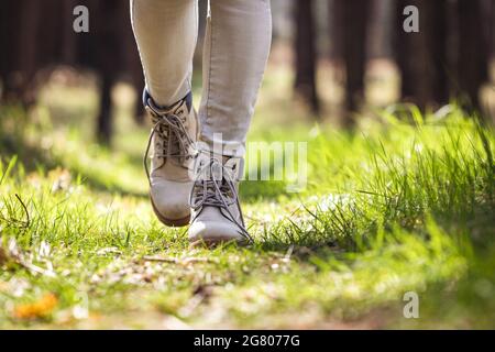Hiking boot. Hiker walking in forest. Female legs wearing leather sports shoe in woodland Stock Photo