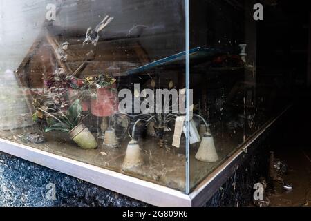 Bad Neuenahr, Germany. 16th July, 2021. Objects destroyed by the flood lie in a muddy shop window. Massive rainfall caused flooding in Bad Neuenahr in Rhineland-Palatinate as well as in the entire district of Ahrweiler. Credit: Philipp von Ditfurth/dpa/Alamy Live News Stock Photo