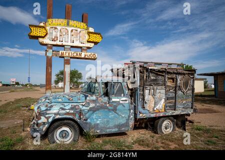 Tucamcari, New Mexico - May 7, 2021: Old rusted neon sign and busted up classic truck at the abandoned Ranch House Cafe along Route 66 Stock Photo