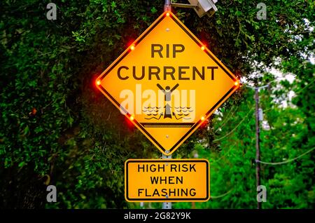 A rip current sign flashes to warn visitors of a high risk of rip currents, July 7, 2021, in Dauphin Island, Alabama. Stock Photo