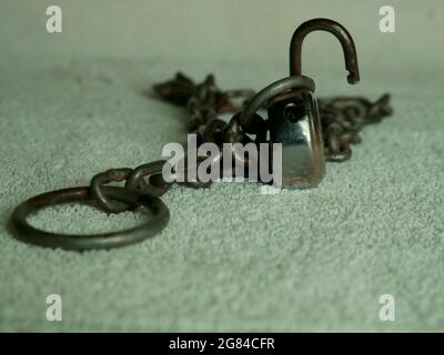 Iron chain with lock Displaying at white fabric, Industrial concept image Stock Photo