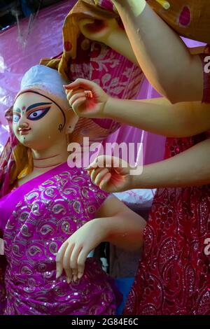 Kolkata, West Bengal, India - 7th October 2018: Clay idol of Goddess Saraswati and hands of Durga, covered under Sari - traditional Indian dress for p Stock Photo