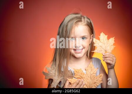 Cute little child are getting ready for autumn. Sale for entire autumn collection, incredible discounts and wonderful choice. Girl in seasonal clothes Stock Photo