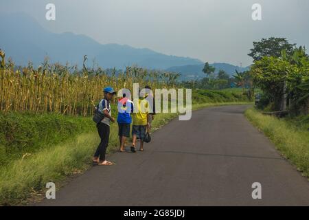Kids playing on the road at the valley of salak mountain Stock Photo