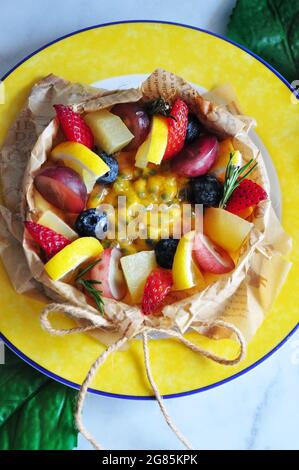 Above of summer fruits and passion fruit sauce top on cheesecake serve on yellow dish Stock Photo