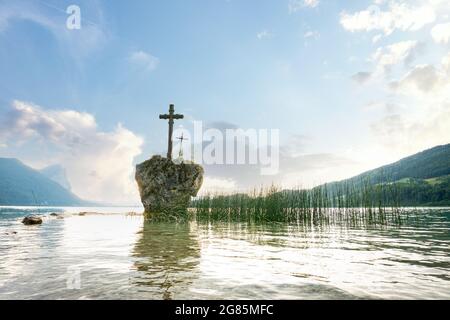 Lake Mondsee in the Salzkammergut during summer time. View to the cross on a rock in Upper Austria, Europe. Stock Photo