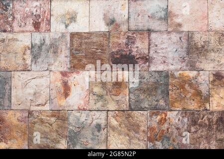 Brown old stone wall, vintage texture, bricks surface, abstract grunge background, square tile pattern, rough granite. Buildings facade. Textured rock Stock Photo