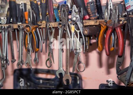 Set of screwdrivers and wrenches hanging on wall with assorted auto  mechanic tools in garage Stock Photo - Alamy