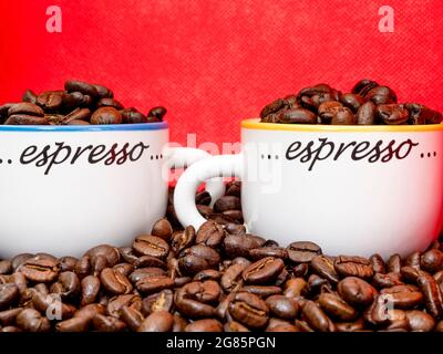 https://l450v.alamy.com/450v/2g85pgn/closeup-pov-shot-of-fresh-whole-roasted-coffee-beans-in-and-around-two-small-espresso-cups-2g85pgn.jpg