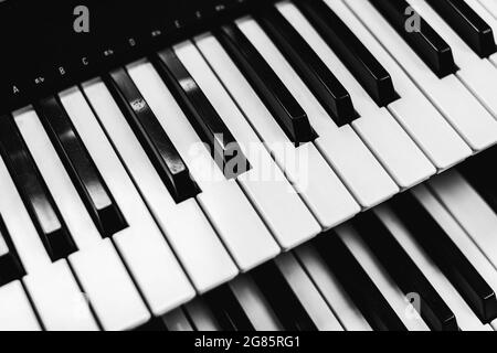 Close focus on upper row of piano keyboard with warm tone of black and white. Stock Photo