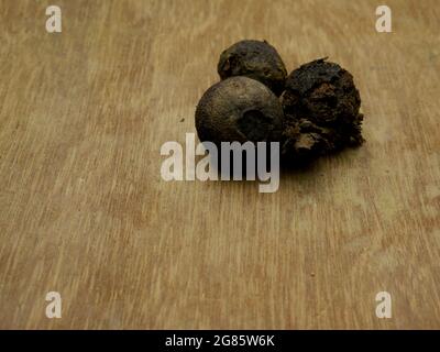 Wastage dry black guava kept on wood floor, text space natural image concept. Stock Photo