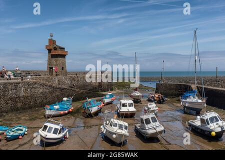 Tide out and boats moored in Lynmouth harbour with the historic Rhenish Tower on the pier. Exmoor National Park, Devon, England UK Stock Photo