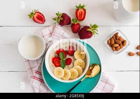 Oatmeal muesli cereal in a bowl with strawberries, banana and almonds. Healthy breakfast Stock Photo