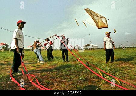 Men flying kite during the 2004 Jakarta International Kite Festival that held on July 9-11 at Karnaval (Carnival) Beach in Ancol Dreamland, North Jakarta, Jakarta, Indonesia. Stock Photo