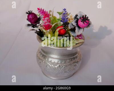 Artificial flower presented on silver metal pot at white background, Nature object image. Stock Photo