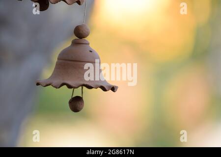 Beautiful terracotta Windchime bell hanging. Blurred background. Traditional clay mud pottery hand made windchime close up made in India Stock Photo
