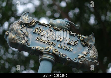 A bilingual road sign in a public park in Thailand that's showing the way to garden Stock Photo
