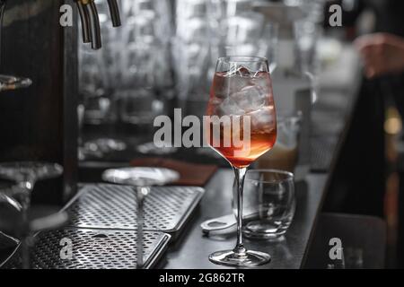 Bartender making aperol spritz summer cocktail in big wine glass Stock Photo