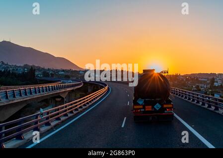 Tank truck with dangerous goods circulating at dawn on a viaduct. Stock Photo