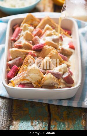 Raw rhubarb  ricotta bread and  butter pudding. Oven ready Stock Photo